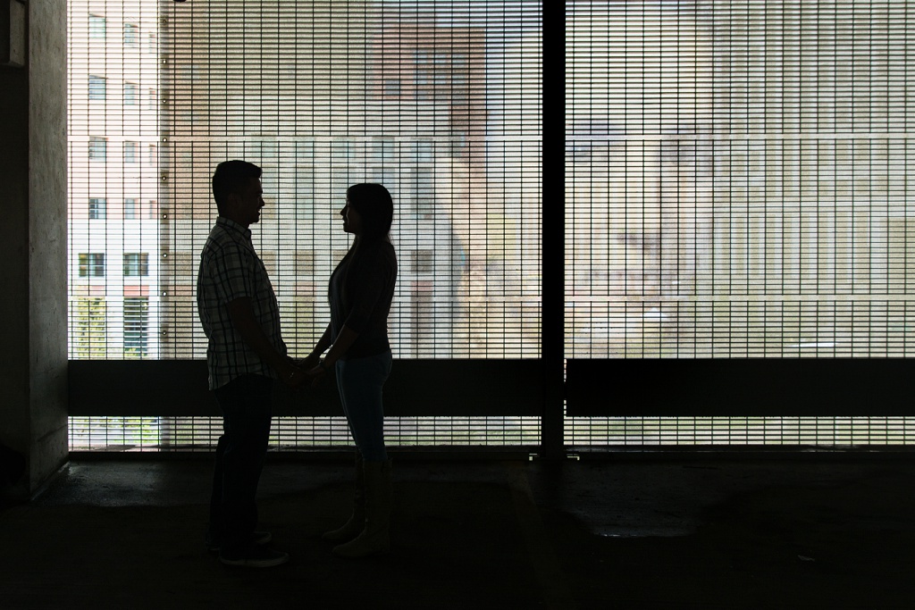 Silhouette of couple against Renaissance art advertisement, parking garage engagement photos, Season Hurd Photography