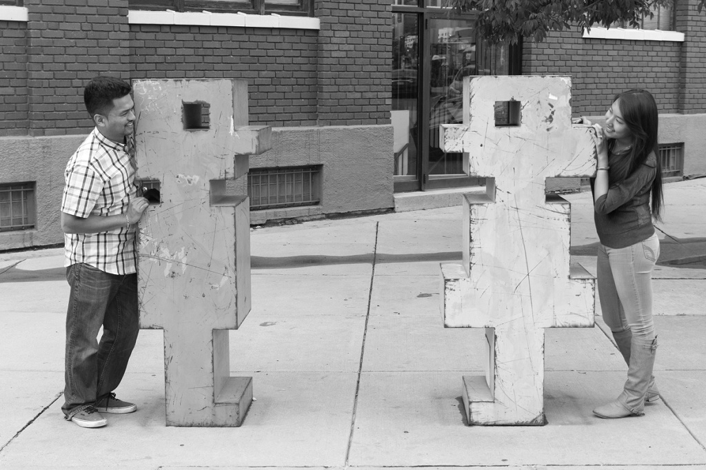 Urban engagement session, couple posing with pixel people statues in Denver's RiNo neighborhood