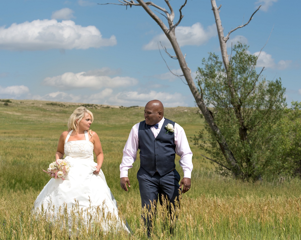 Bride and groom standing in a green field, Colorado farm wedding photos