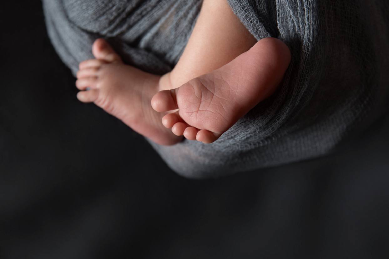 Newborn baby feet with low key lighting