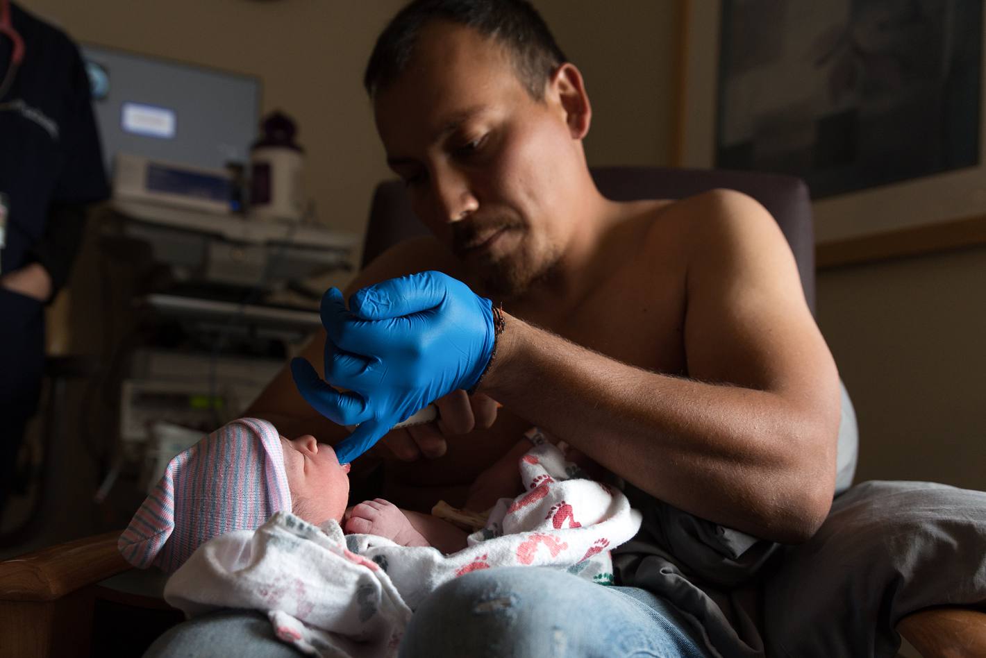 Dad feeding newborn with donor milk