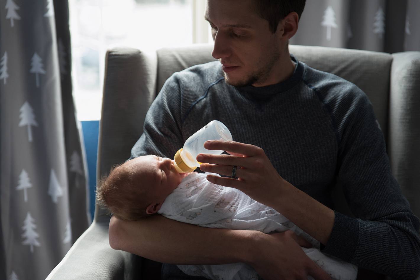 Dad feeding baby a bottle, in home newborn lifestyle photography