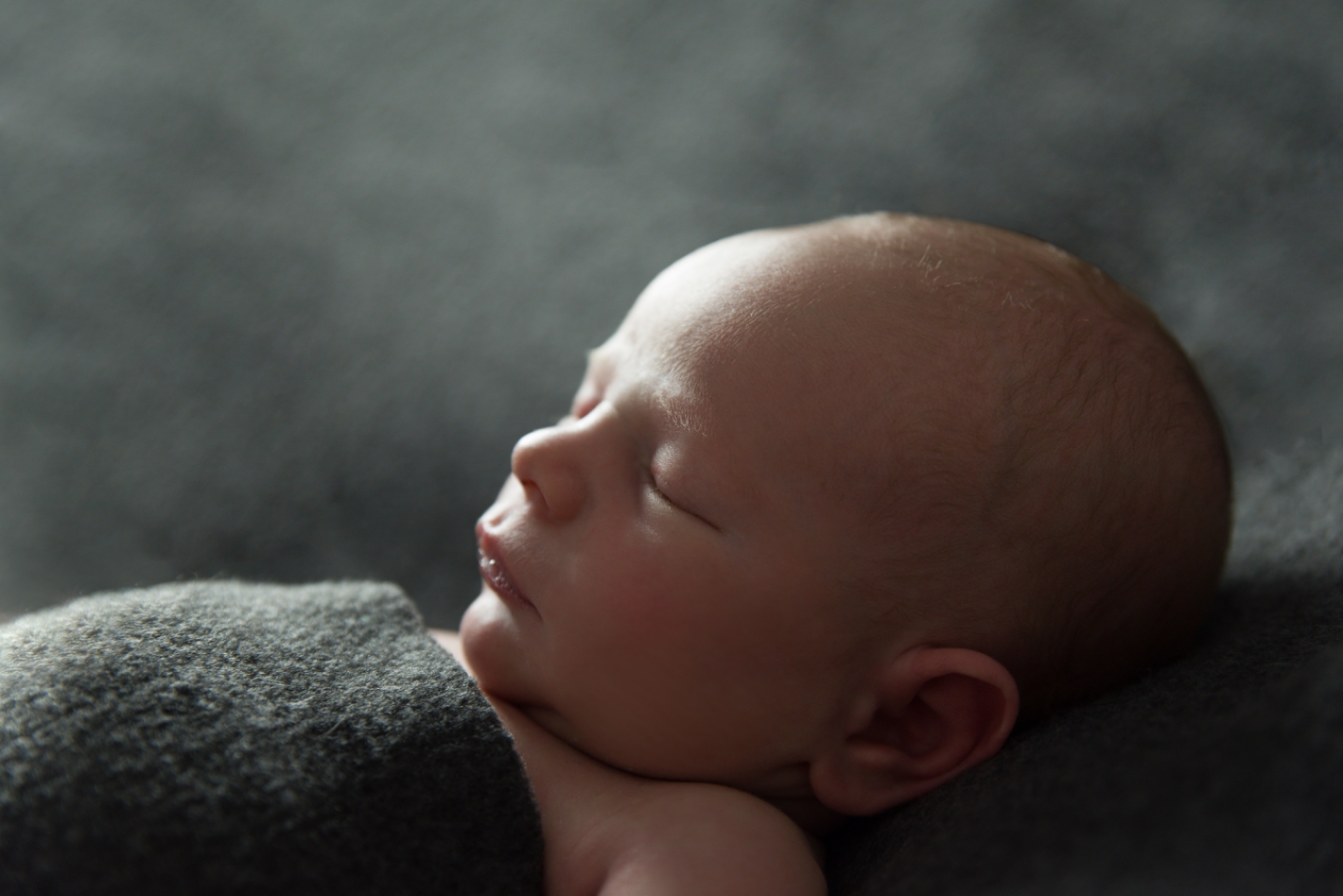Newborn photography on charcoal grey backdrop