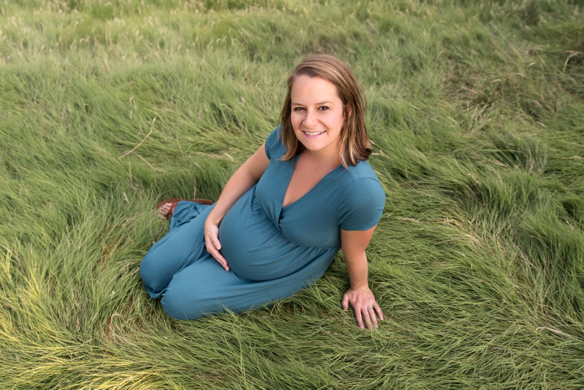Maternity photos sitting in the grass