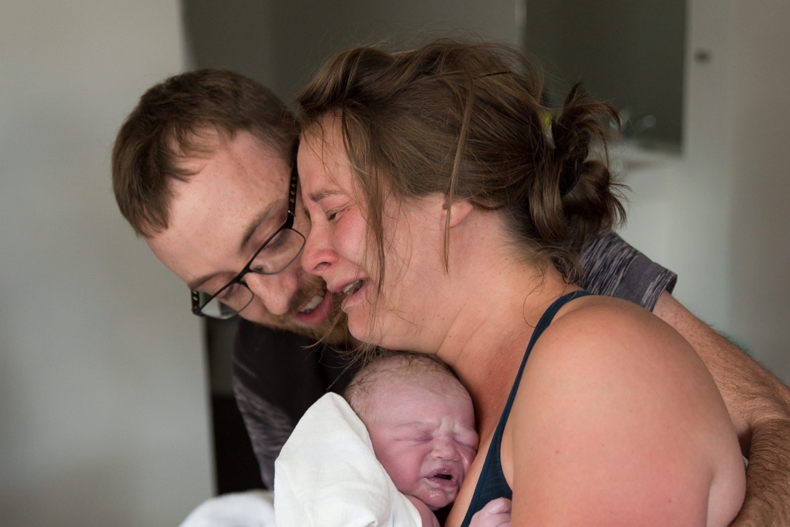 Mom and dad crying while holding minutes old newborn baby