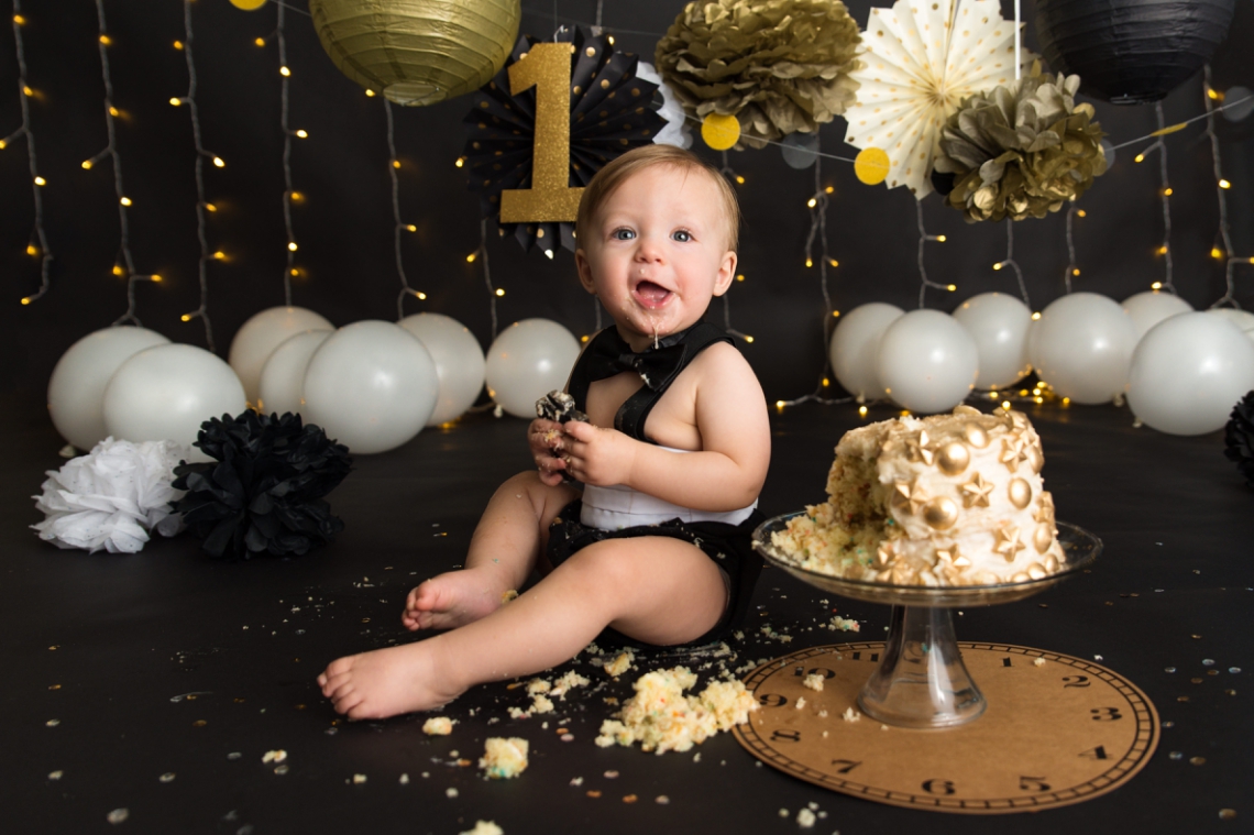Black backdrop with gold and white decorations New Years cake smash