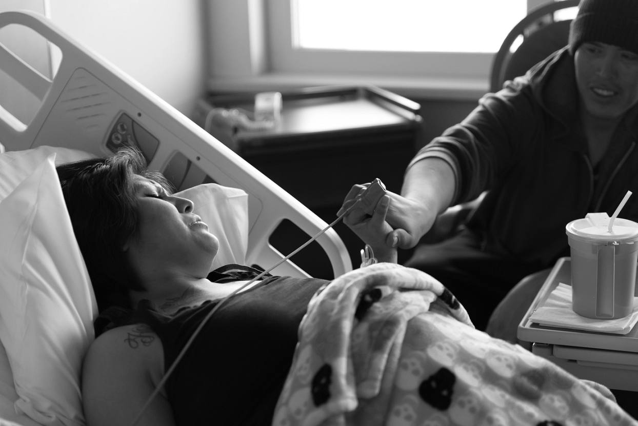 Birth photography, mom and dad holding hands through contractions