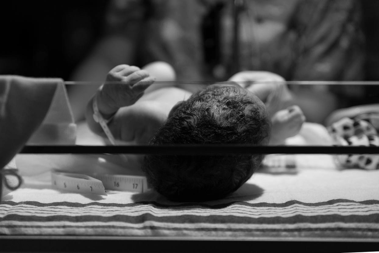 Baby in incubator after birth, black and white