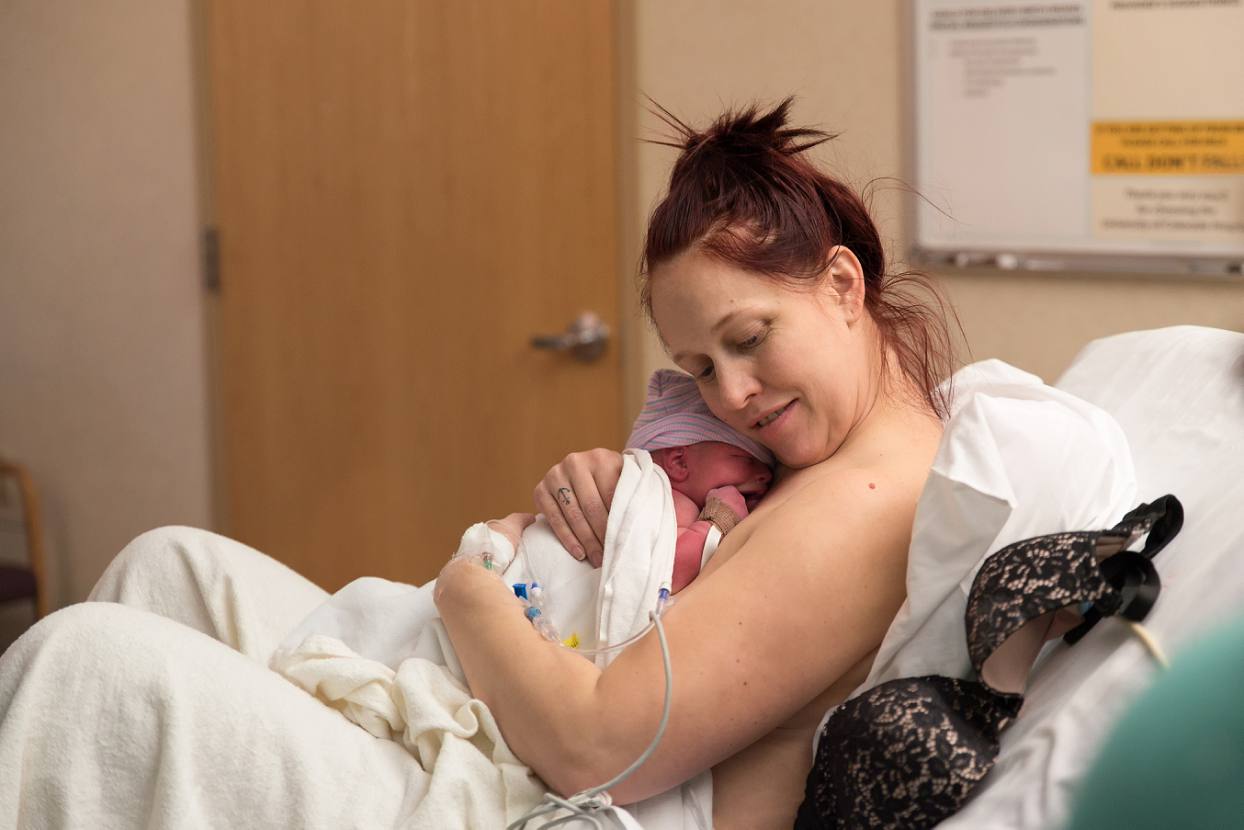 Mother hugging her newborn, baby's first hug