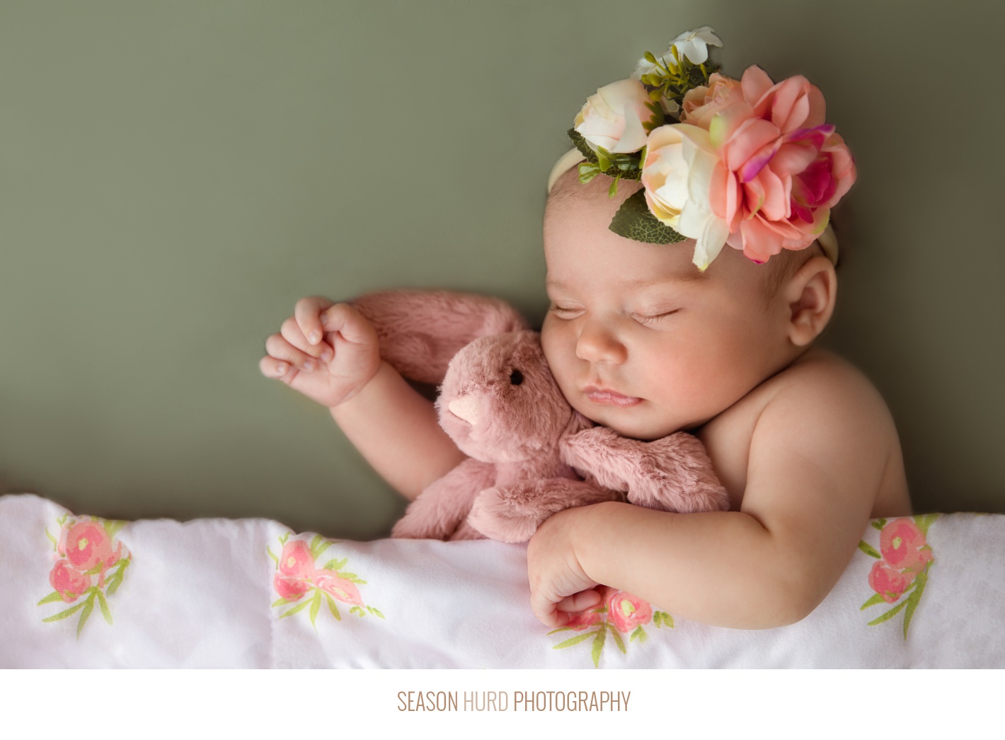 Newborn girl in floral headband and green background