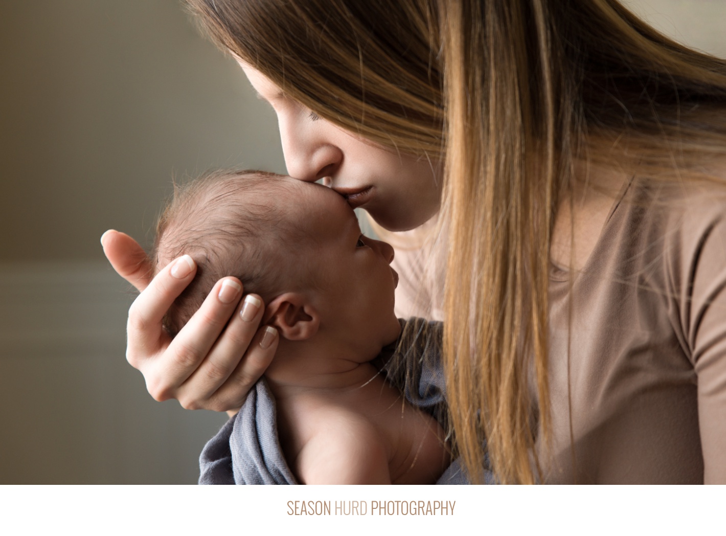 Mother kissing baby on forehead, newborn photography